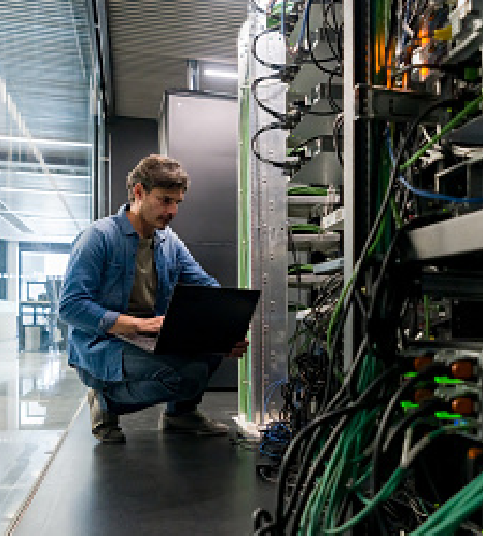 Worker with a laptop inspecting servers